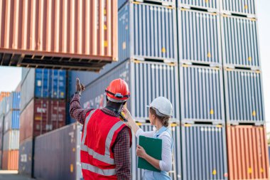 Foreman kontrol kargo nakliye gemisinden ithalat için konteynır kutusu yüklüyor. Deniz limanında nakliye konteynırları.