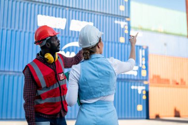 Foreman kontrol kargo nakliye gemisinden ithalat için konteynır kutusu yüklüyor. Deniz limanında nakliye konteynırları.