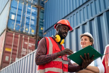 Foreman kontrol kargo nakliye gemisinden ithalat için konteynır kutusu yüklüyor. Deniz limanında nakliye konteynırları.