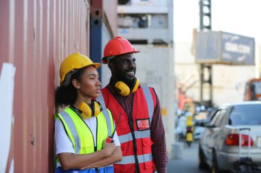 Foreman kontrol kargo nakliye gemisinden ithalat için konteynır kutusu yüklüyor. Deniz limanında nakliye konteynırları.