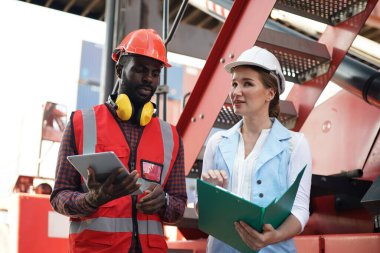 Foreman kontrol kargo nakliye gemisinden ithalat için konteynır kutusu yüklüyor. Deniz limanında nakliye konteynırları.