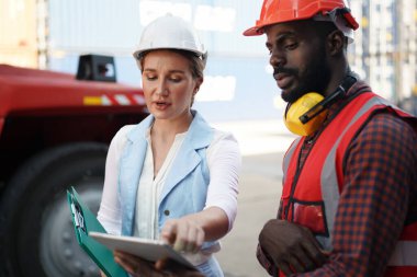 Foreman kontrol kargo nakliye gemisinden ithalat için konteynır kutusu yüklüyor. Deniz limanında nakliye konteynırları.