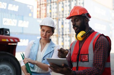 Foreman kontrol kargo nakliye gemisinden ithalat için konteynır kutusu yüklüyor. Deniz limanında nakliye konteynırları.