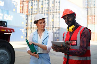 Foreman kontrol kargo nakliye gemisinden ithalat için konteynır kutusu yüklüyor. Deniz limanında nakliye konteynırları.