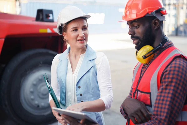 Foreman kontrol kargo nakliye gemisinden ithalat için konteynır kutusu yüklüyor. Deniz limanında nakliye konteynırları.