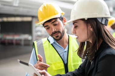 Fabrikada tabletle konuşan endüstriyel bir erkek ve kadın mühendisin portresi..