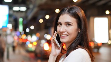 Genç kadın konuşurken birileriyle onun cep telefonu süre seyir içine mesafe mutlu yüz ifadesi ile kapatmak.