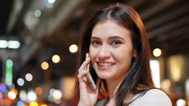Genç kadın konuşurken birileriyle onun cep telefonu süre seyir içine mesafe mutlu yüz ifadesi ile kapatmak.