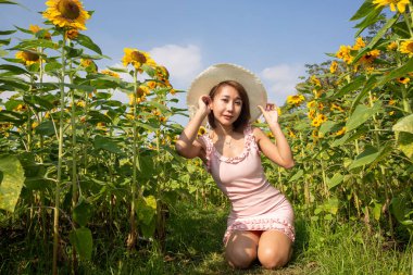 Ayçiçeği tarlasındaki Asyalı kadın. Açık hava portresi..