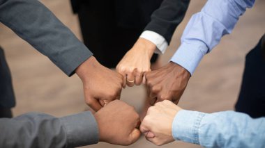 Birleşik iş arkadaşları modern ofiste ellerini birleştirip zaferi, takım oluşturmayı ve birlik olmayı kutluyorlar. 