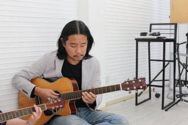 Stüdyoda gitar çalan müzisyen portresi.