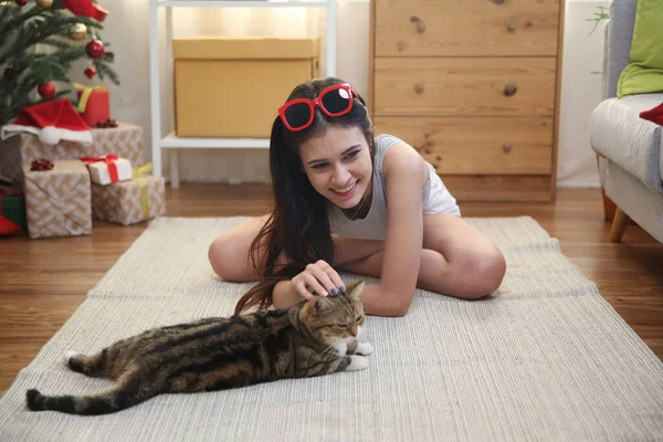 若い女性は床の上で猫と遊ぶ — ストック写真