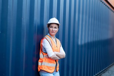 Ustabaşı kontrolü, kargo nakliye gemisinden ithal etmek için konteynır kutusu yüklüyor..