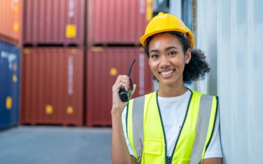 Ustabaşı kontrolü, kargo nakliye gemisinden ithal etmek için konteynır kutusu yüklüyor..