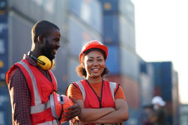 Ustabaşı kontrolü, kargo nakliye gemisinden ithal etmek için konteynır kutusu yüklüyor..