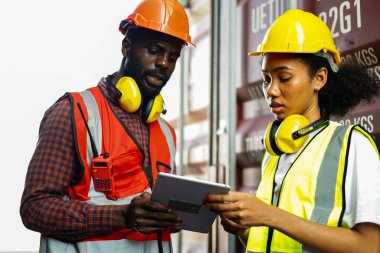 Ustabaşı kontrolü, kargo nakliye gemisinden ithal etmek için konteynır kutusu yüklüyor..