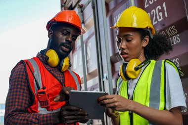 Ustabaşı kontrolü, kargo nakliye gemisinden ithal etmek için konteynır kutusu yüklüyor..
