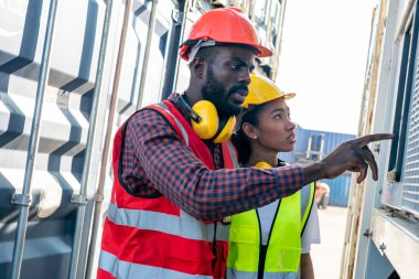 Ustabaşı kontrolü, kargo nakliye gemisinden ithal etmek için konteynır kutusu yüklüyor..