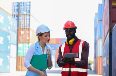 Ustabaşı kontrolü, kargo nakliye gemisinden ithal etmek için konteynır kutusu yüklüyor..