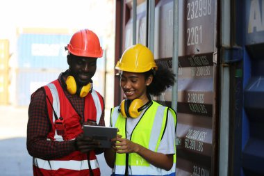 Ustabaşı kontrolü, kargo nakliye gemisinden ithal etmek için konteynır kutusu yüklüyor..