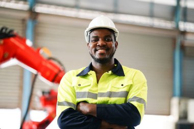 Mühendis kontrol paneli ve fabrikada yeni otomatik robot kolu ve işletim kontrol makinesini öğretiyor.