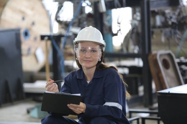 Mühendis kontrol paneli ve fabrikada yeni otomatik robot kolu ve işletim kontrol makinesini öğretiyor.