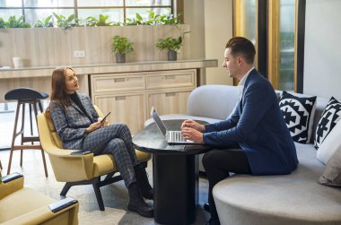 Girişimlerde çalışan insanlar, iki iş adamı bilgisayarlarını kullanırken gülümseyen ve beyin fırtınası yapan insanlar.