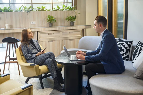 Girişimlerde çalışan insanlar, iki iş adamı bilgisayarlarını kullanırken gülümseyen ve beyin fırtınası yapan insanlar.