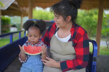 Anne ve kız bahçede, çeşitli ailelerde ve en iyi arkadaşlarla mutlu annelik hafta sonları çocuklarla, Anneler Günü konseptiyle dışarıda aktiviteler yapıyorlar.
