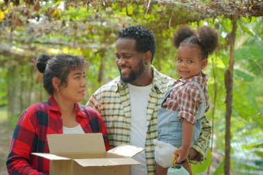 Kızıyla birlikte organik çiftlikte vakit geçiren melez bir aile. Afro-Amerikan ailesi.