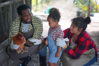 Kızıyla birlikte organik çiftlikte vakit geçiren melez bir aile. Afro-Amerikan ailesi.