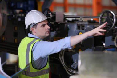 Ustabaşı ya da işçi fabrikada çalışıyor. Kontrol makinesi ya da tesisteki ürünler. Mühendis ya da teknisyen Malzemeleri ya da Tesiste Makine 'yi kontrol ediyor. Endüstriyel ve Fabrika. Metal endüstrisinde çok ırklı işçiler konuşuyor. Meslektaşlar bir konuyu tartışıyor.. 