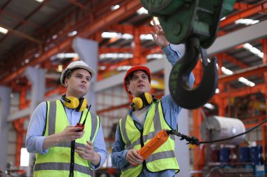 Ustabaşı ya da işçi fabrikada çalışıyor. Kontrol makinesi ya da tesisteki ürünler. Mühendis ya da teknisyen Malzemeleri ya da Tesiste Makine 'yi kontrol ediyor. Endüstriyel ve Fabrika. Metal endüstrisinde çok ırklı işçiler konuşuyor. Meslektaşlar bir konuyu tartışıyor.. 