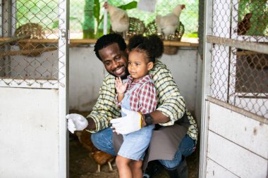 Kızıyla birlikte organik çiftlikte vakit geçiren melez bir aile. Afro-Amerikan ailesi.