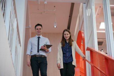 Genç iş adamları ve meslektaşlarının toplantıda laptopta ve dokunmatik kağıtları tartışırken görüntüsü