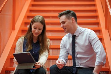 Genç iş adamları ve meslektaşlarının toplantıda laptopta ve dokunmatik kağıtları tartışırken görüntüsü