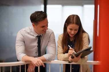 Genç iş adamları ve meslektaşlarının toplantıda laptopta ve dokunmatik kağıtları tartışırken görüntüsü