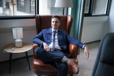 Modern ofis binasındaki başarılı iş adamının portresi. İş adamı kameraya bakıyor ve gülümsüyor. Yakışıklı bir adamın portresi.