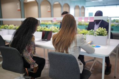 Genç iş adamları ve meslektaşlarının toplantıda laptopta ve dokunmatik kağıtları tartışırken görüntüsü