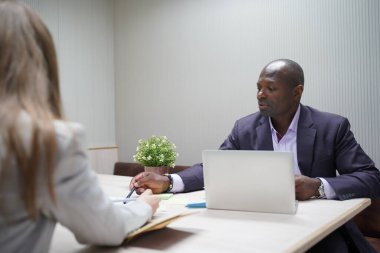 Genç iş adamları ve meslektaşlarının toplantıda laptopta ve dokunmatik kağıtları tartışırken görüntüsü