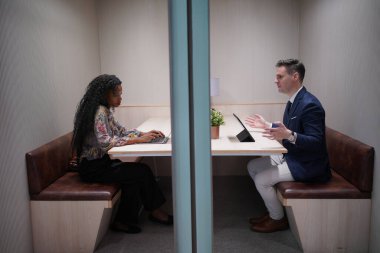 Genç iş adamları ve meslektaşlarının toplantıda laptopta ve dokunmatik kağıtları tartışırken görüntüsü