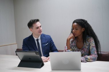 Genç iş adamları ve meslektaşlarının toplantıda laptopta ve dokunmatik kağıtları tartışırken görüntüsü