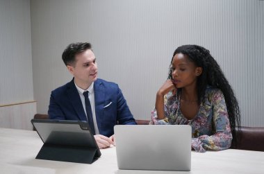 Genç iş adamları ve meslektaşlarının toplantıda laptopta ve dokunmatik kağıtları tartışırken görüntüsü