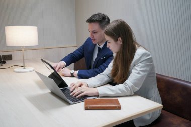 Genç iş adamları ve meslektaşlarının toplantıda laptopta ve dokunmatik kağıtları tartışırken görüntüsü