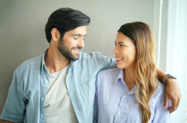 Güzel, mutlu, genç bir çift evde birbirini kucaklıyor.