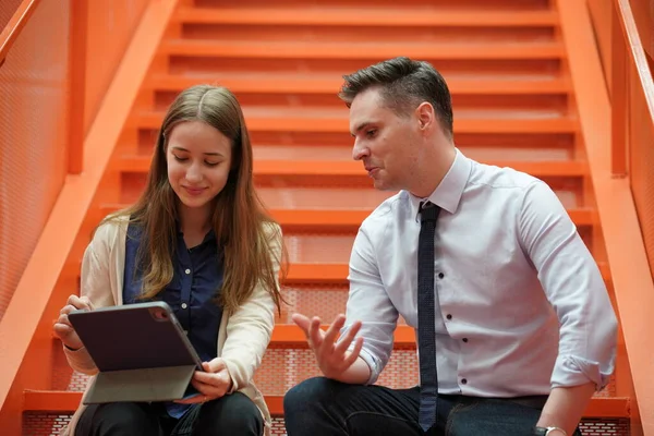 Genç iş adamları ve meslektaşlarının toplantıda laptopta ve dokunmatik kağıtları tartışırken görüntüsü