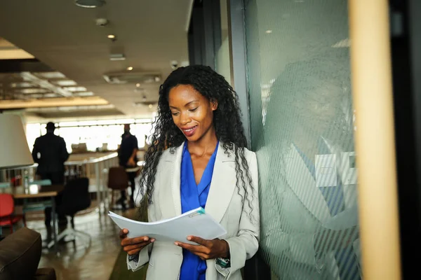 İspanyol asıllı ve özgüvenli afro iş kadını, yeni açılan modern ofiste çalışıyor..