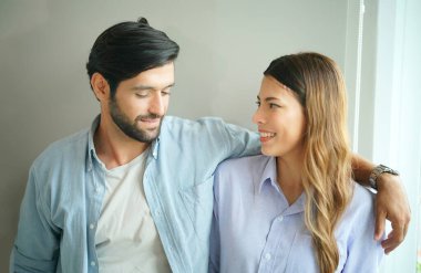 Güzel, mutlu, genç bir çift evde birbirini kucaklıyor.