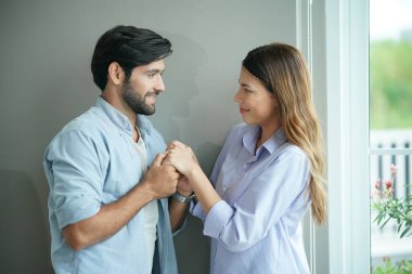 Güzel, mutlu, genç bir çift evde birbirini kucaklıyor.