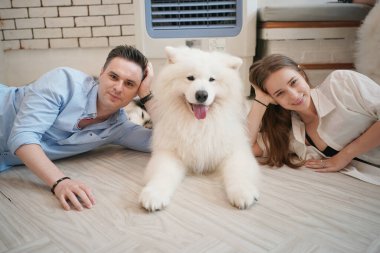 Evcil köpeğiyle yerde oynayan bir adam ve kız. Mutlu köpek, köpekli mutlu adam..